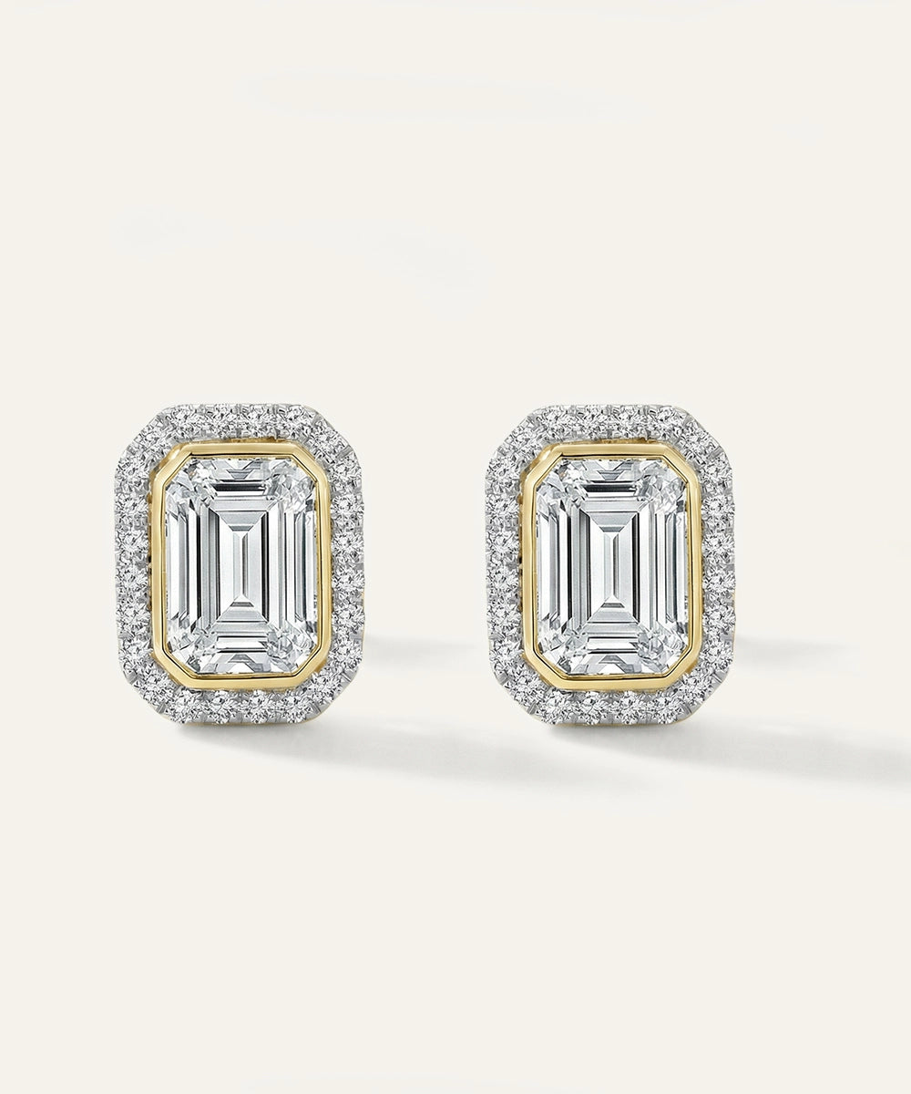 Pair of diamond earrings with gold and silver accents on a light gray background