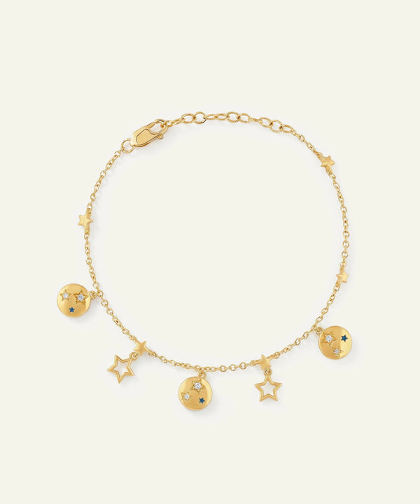 Gold bracelet with star and moon charms on a white background