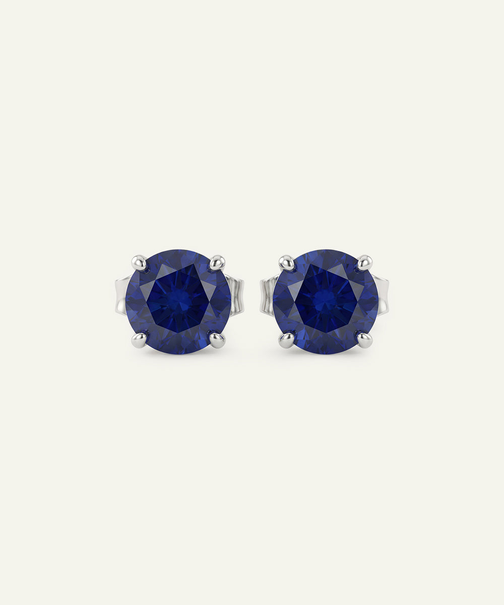 Pair of blue gemstone stud earrings on a white background