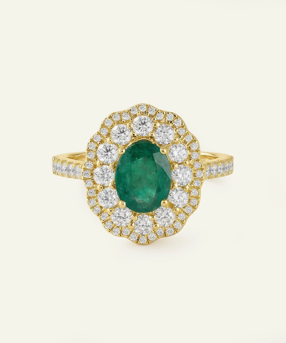 Gold ring with a green gemstone and white diamonds on a light beige background