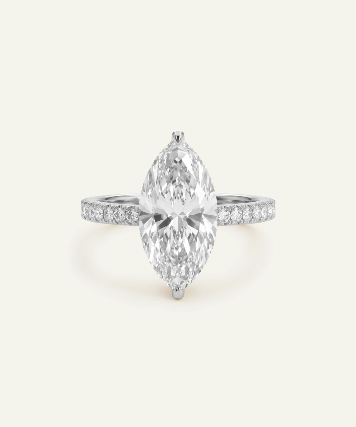 A marquise-cut diamond engagement ring in a silver-colored setting with pavé diamonds on the band, centered on a light cream background.