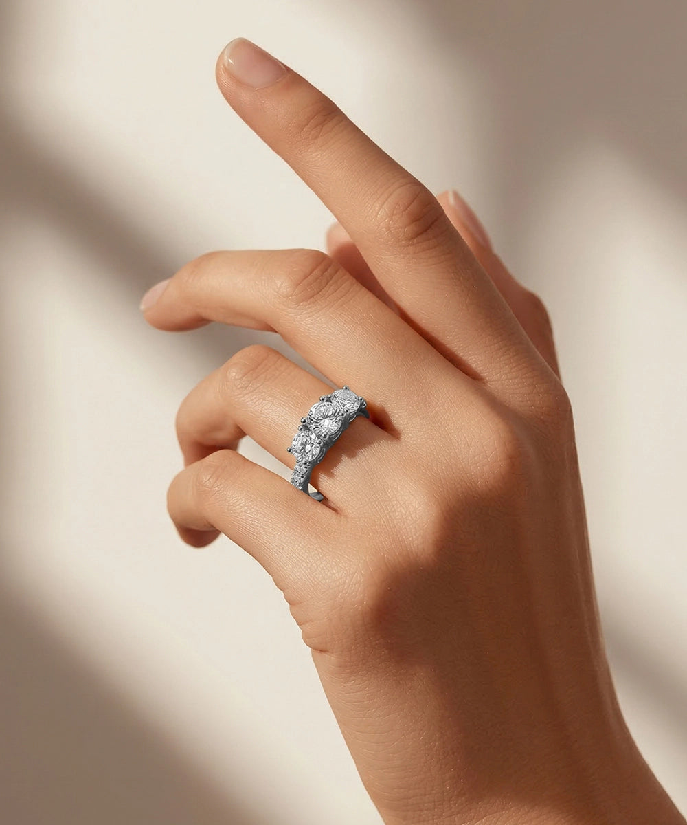 Hand wearing a diamond ring on a neutral background
