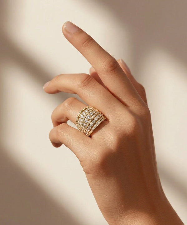 Hand wearing a gold ring with diamonds on a soft background