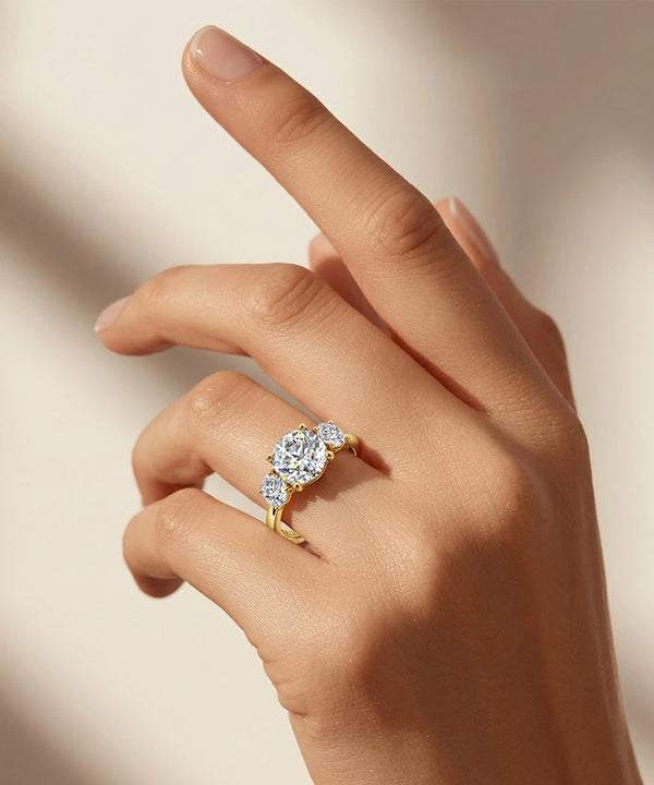 Gold ring with a diamond on a hand against a neutral background