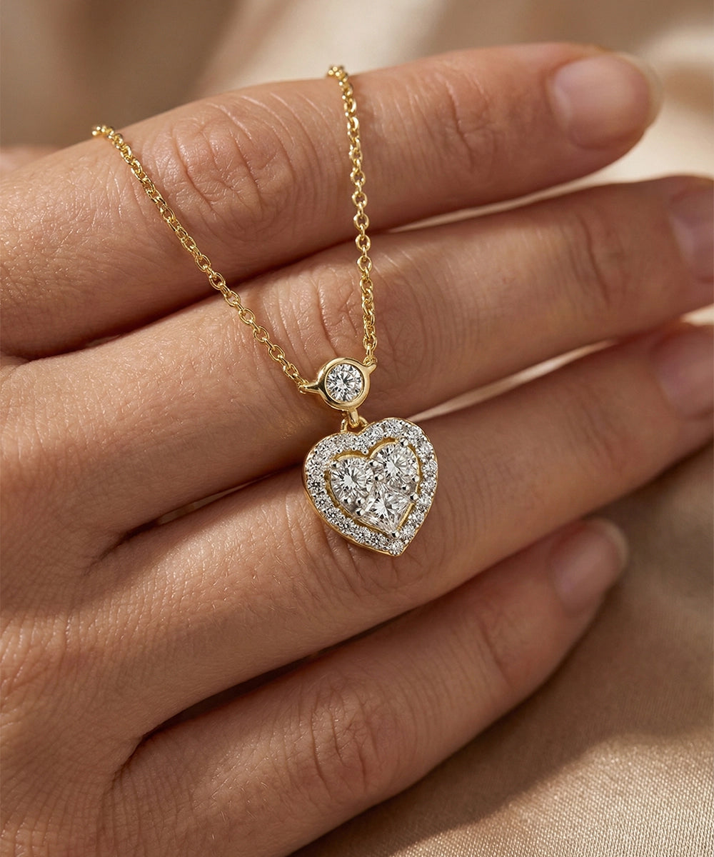 Gold necklace with a heart-shaped pendant on a hand against a beige background