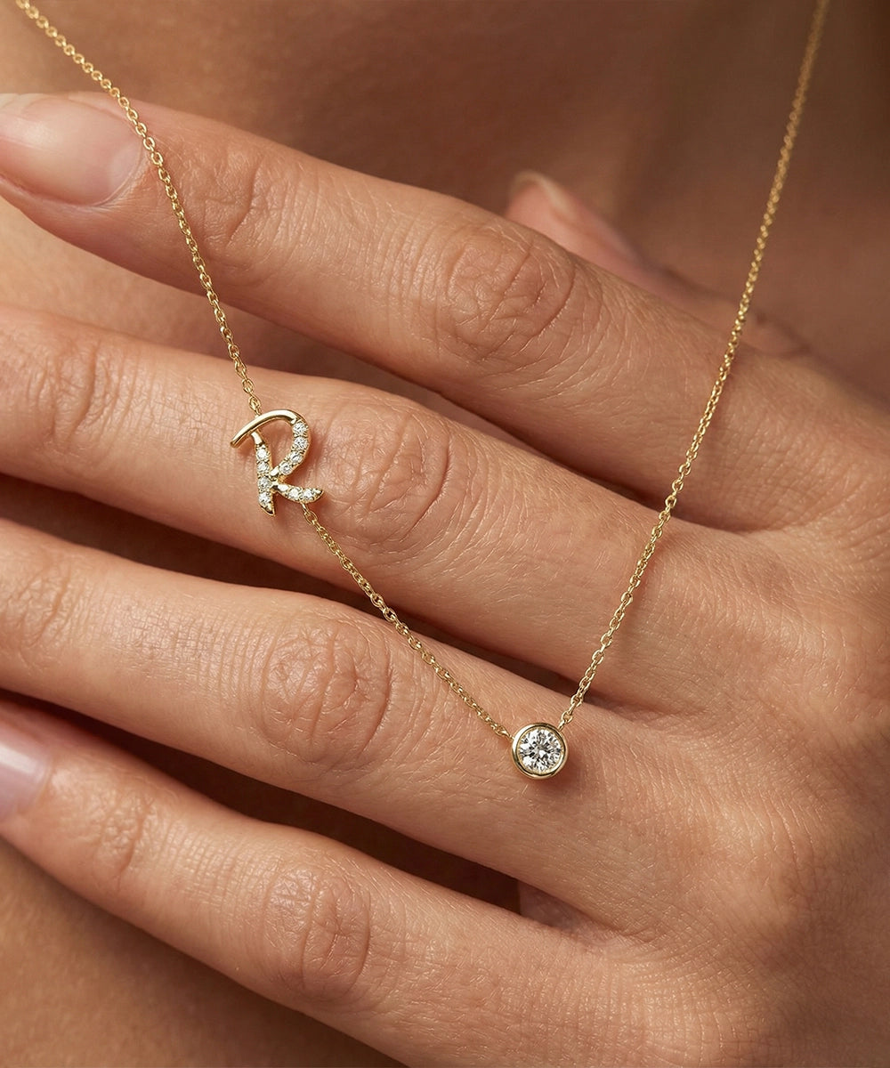 Gold necklace with a small round pendant on a hand