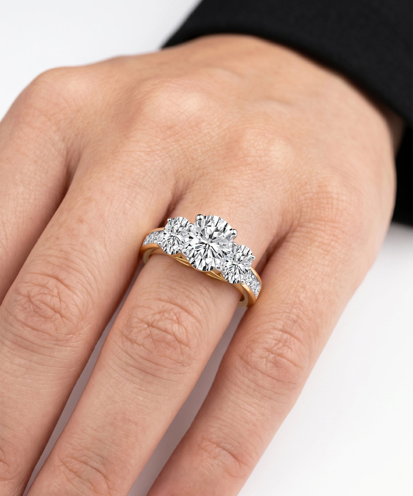 Diamond ring on a person's finger against a neutral background