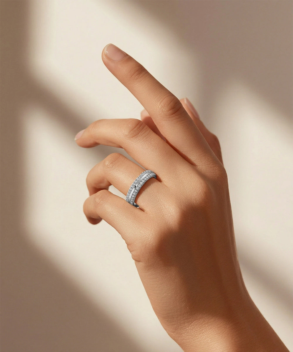 Hand wearing a diamond ring on a neutral background