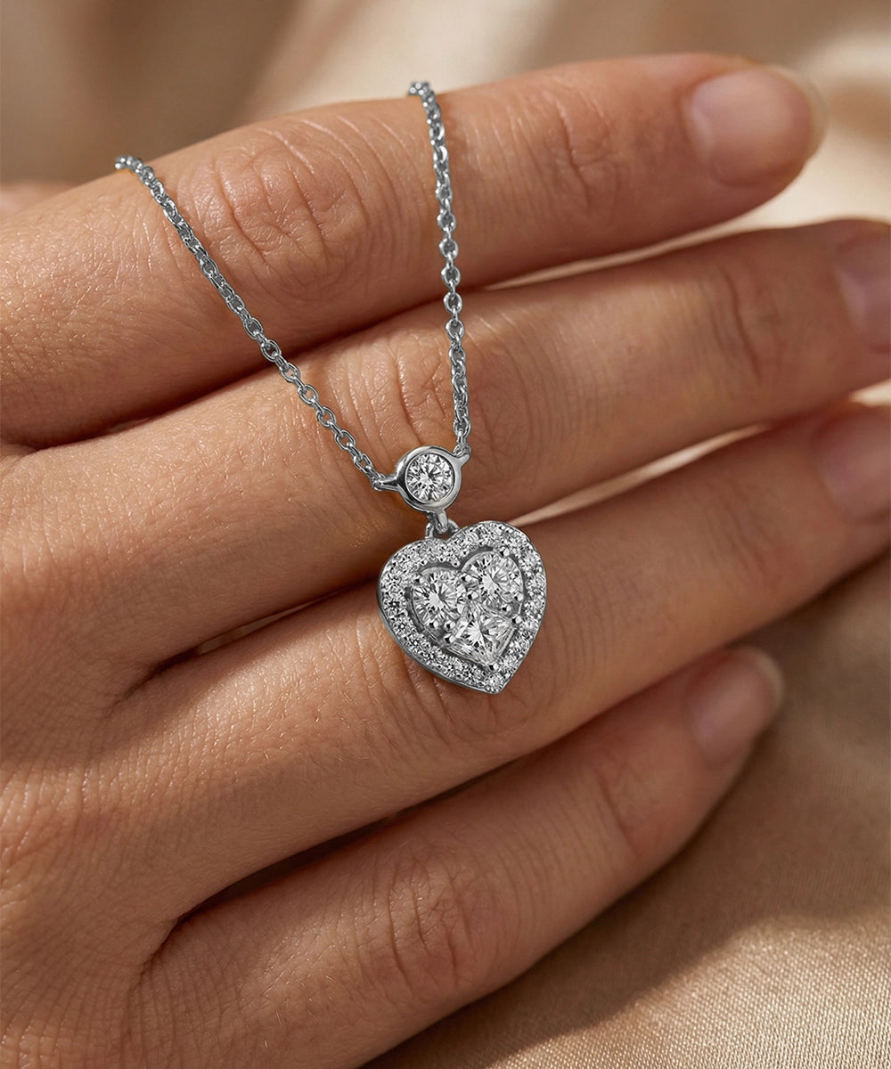 Silver heart-shaped pendant necklace on a hand