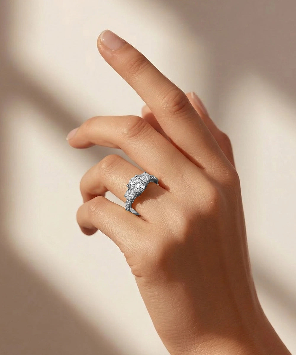 Hand wearing a diamond ring on a neutral background