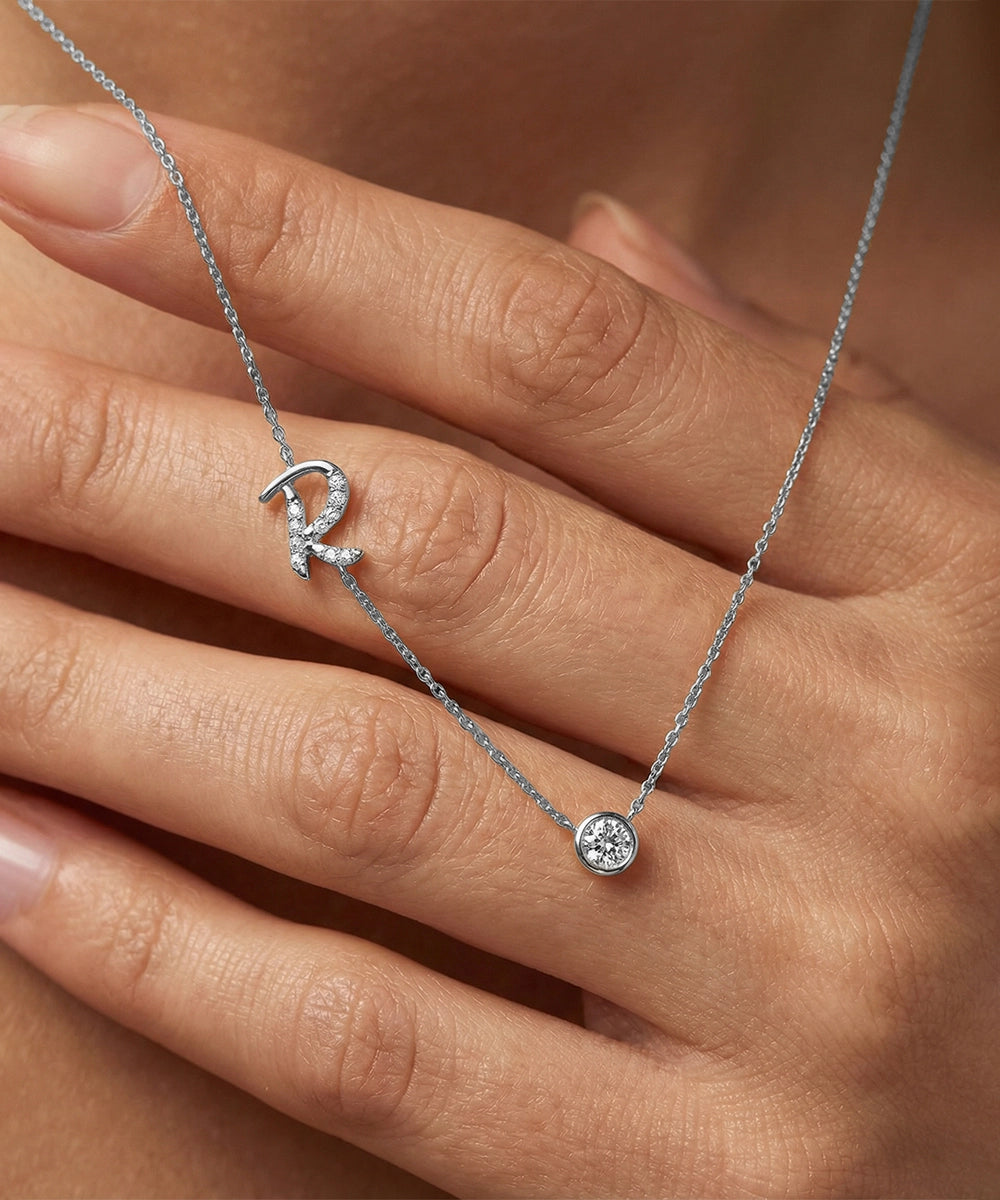 Silver necklace with a round pendant on a hand