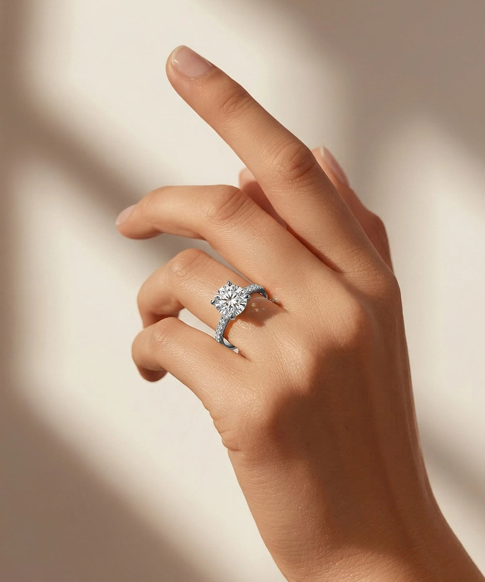 Hand wearing a diamond ring on a neutral background
