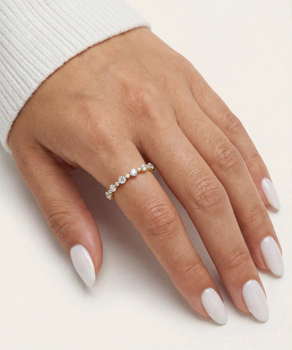 Hand wearing a diamond ring on a light background