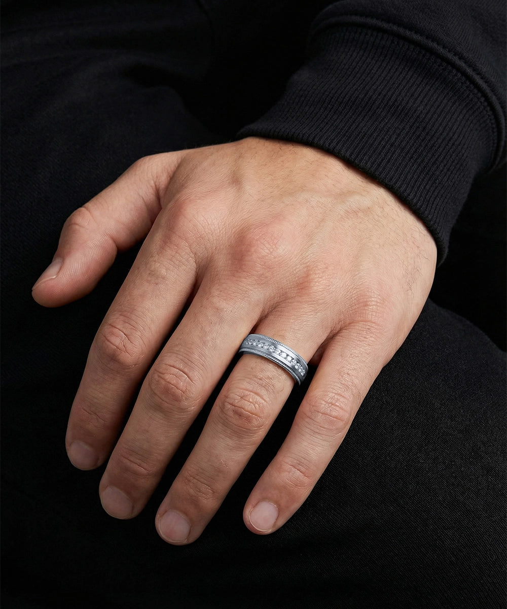 Hand wearing a silver ring with a black background