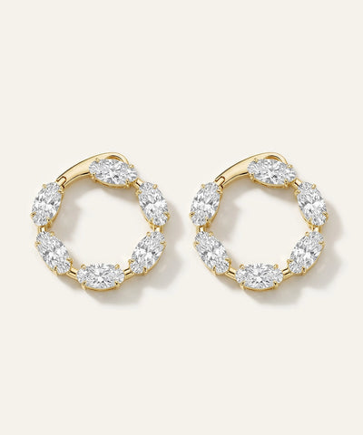 Gold hoop earrings with clear gemstones on a white background