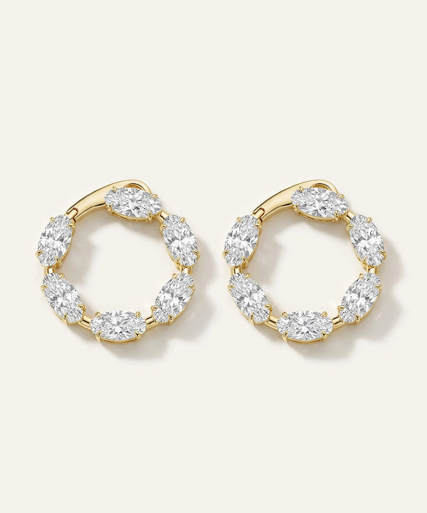 Gold hoop earrings with clear gemstones on a white background