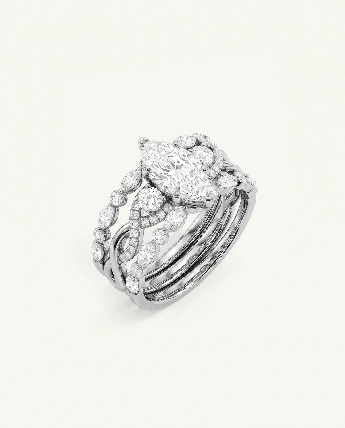 A silver-toned multi-band ring featuring a marquise-cut center stone and smaller round stones, photographed on a clean off-white background.