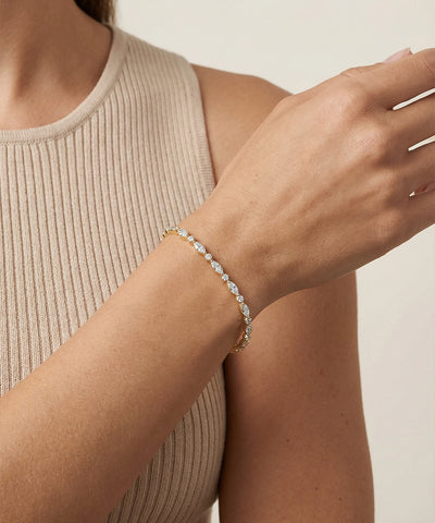 Close-up of a person wearing a delicate bracelet on a neutral background - alternate view