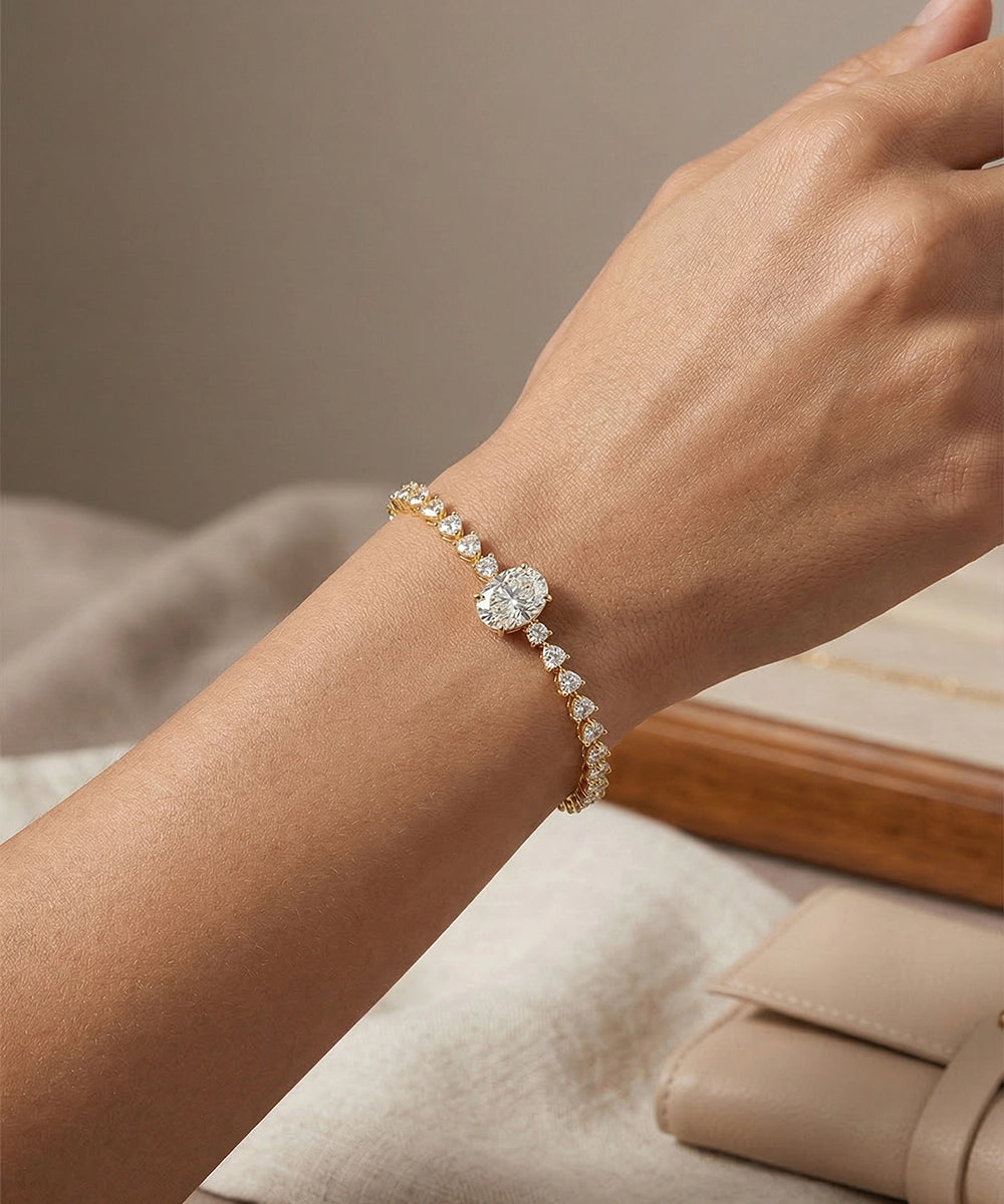Gold bracelet with a diamond on a wrist against a neutral background