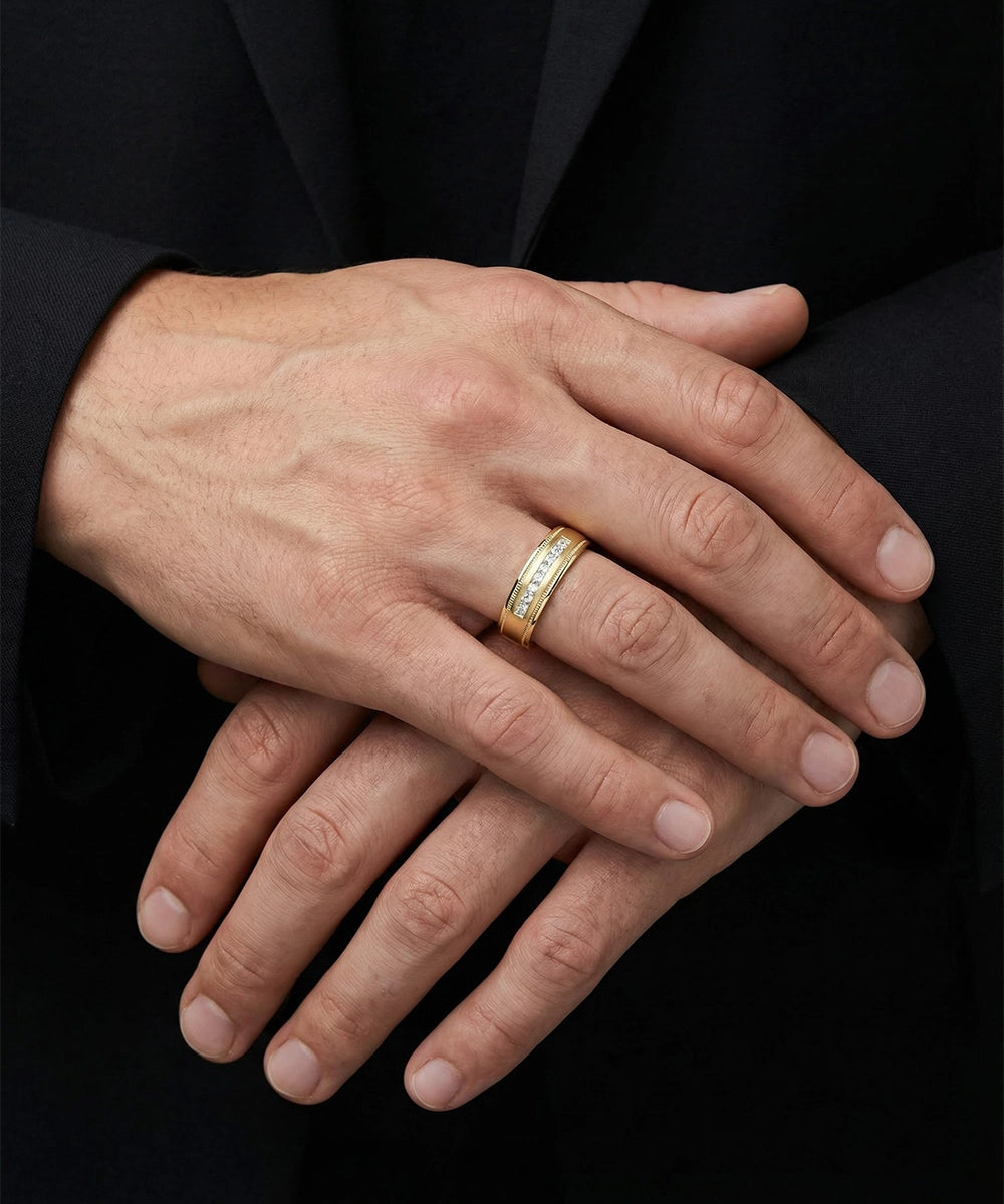 Close-up of a hand wearing a gold ring with a black background