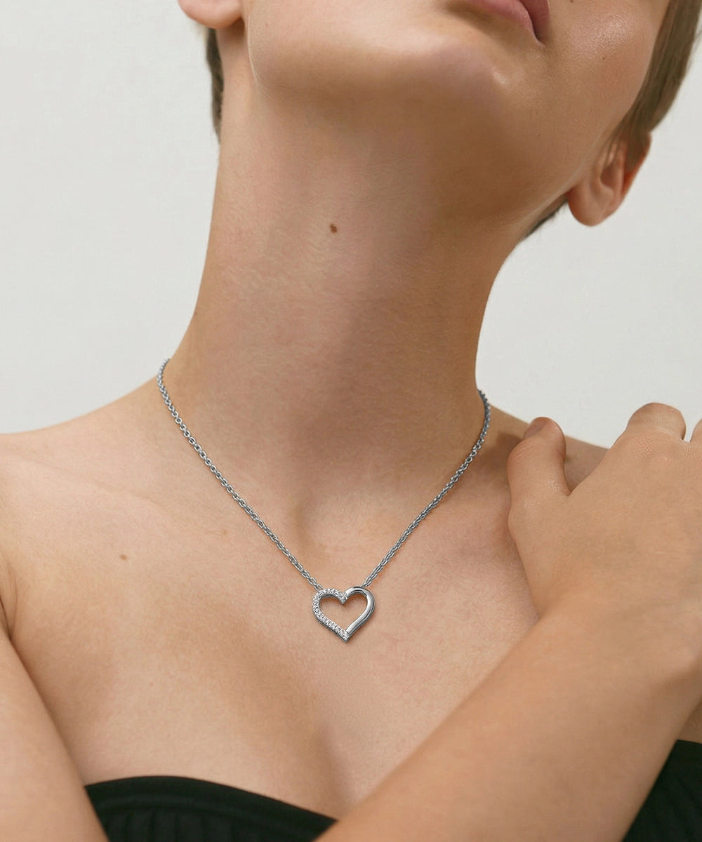 Necklace with a heart-shaped pendant worn by a person on a neutral background