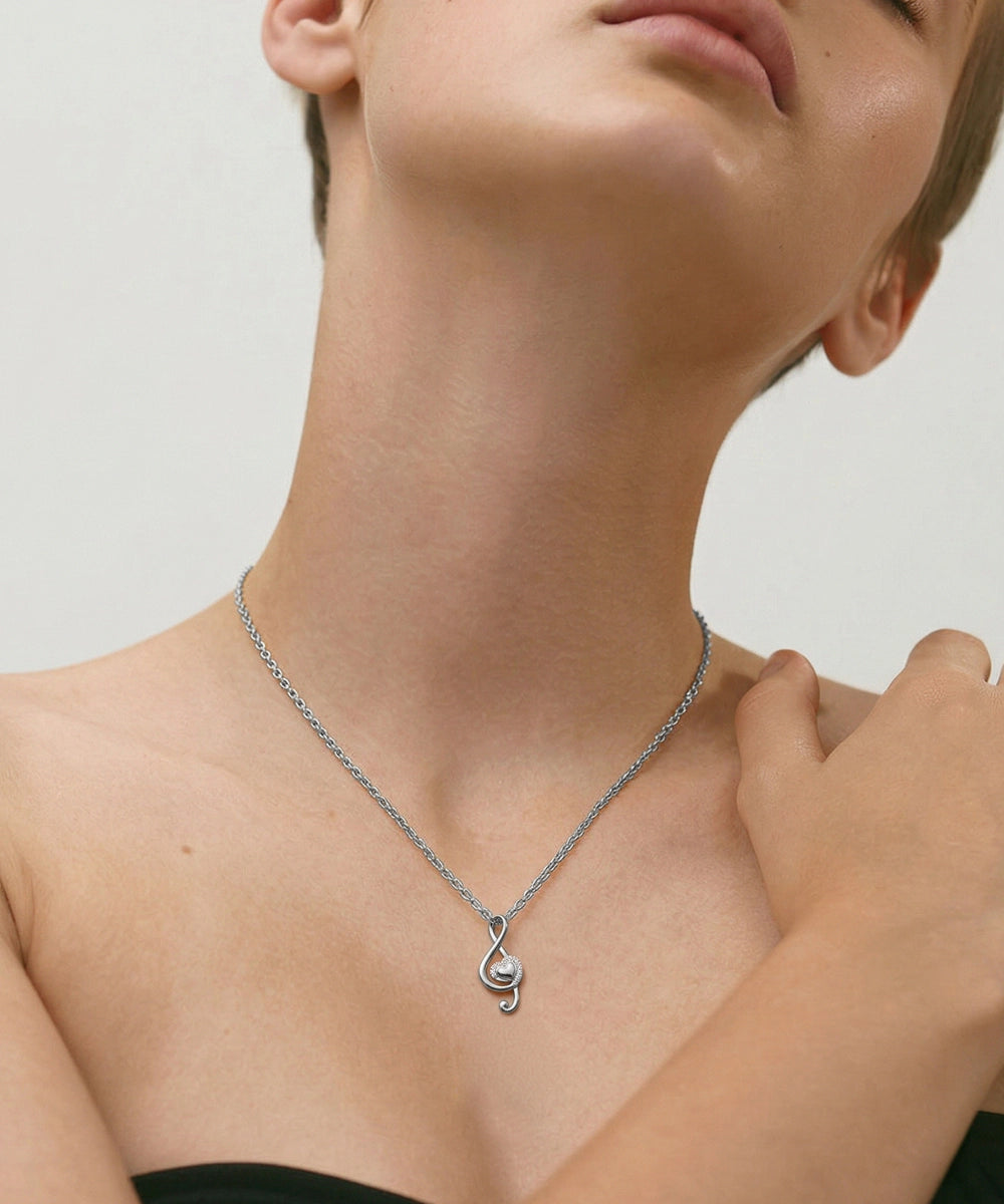 Person wearing a silver necklace with a unique pendant on a neutral background