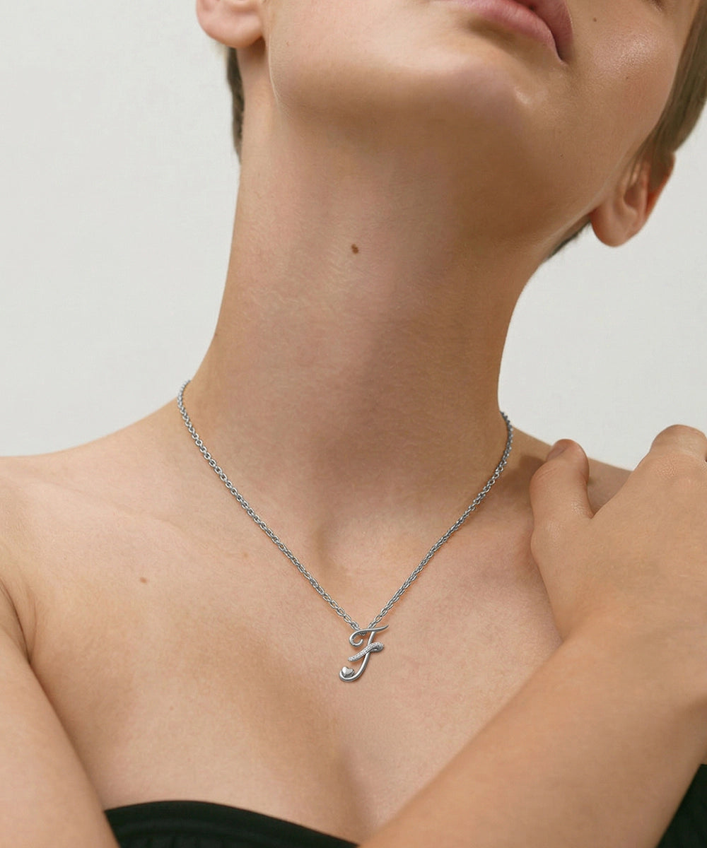 Silver necklace with a unique pendant worn by a person against a neutral background