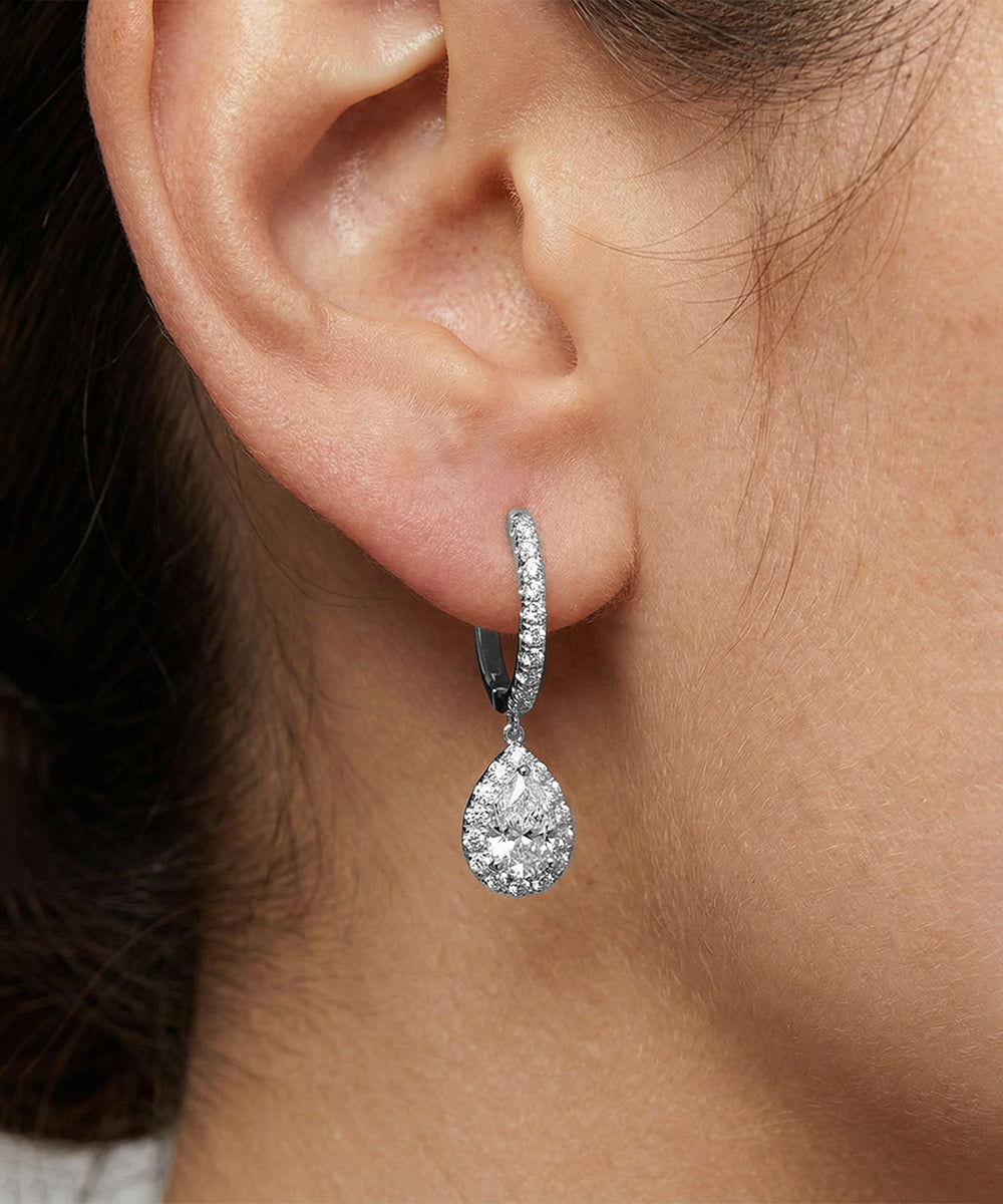 Teardrop-shaped diamond earring worn by a person