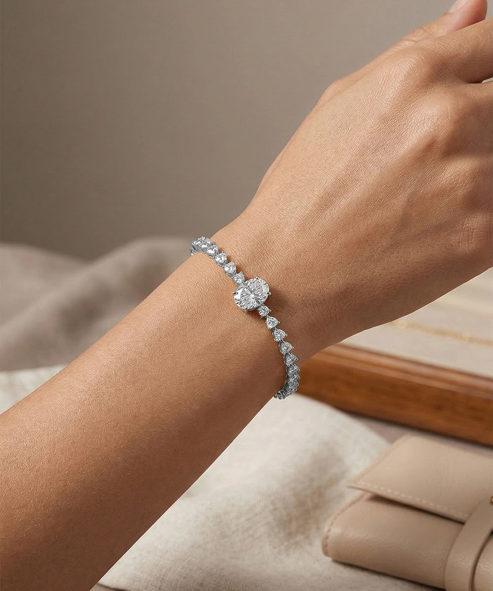 Silver bracelet with a large central gemstone on a wrist against a neutral background