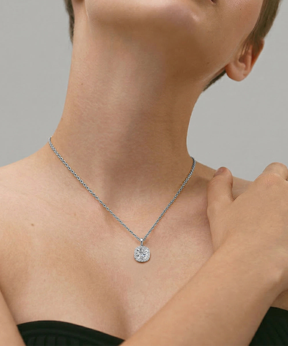 Necklace with a round pendant worn by a person against a neutral background