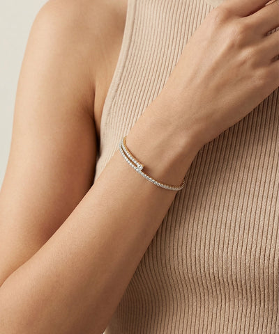 Silver bracelet on a person's wrist with a neutral background - alternate view