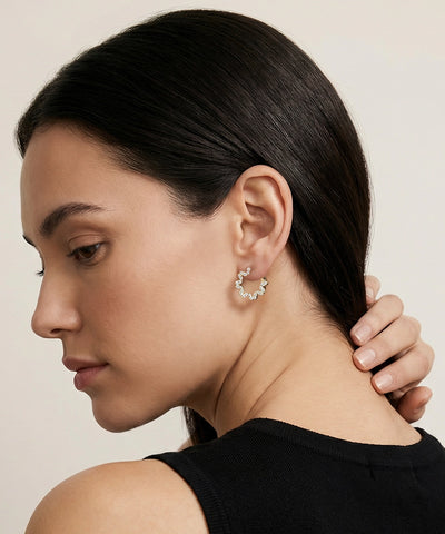 Woman wearing a delicate earring with a neutral background - alternate view