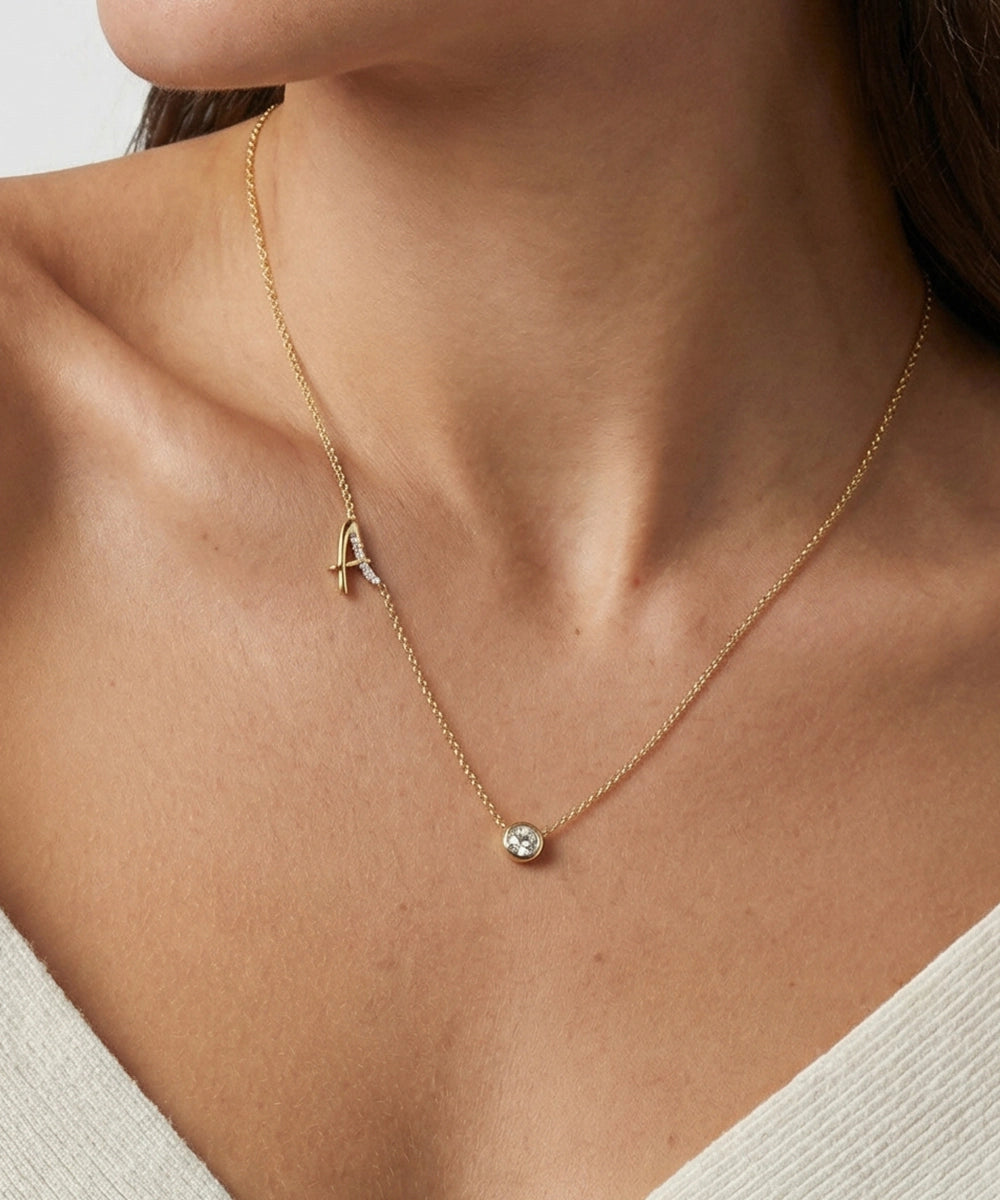 Gold necklace with a small pendant worn by a person