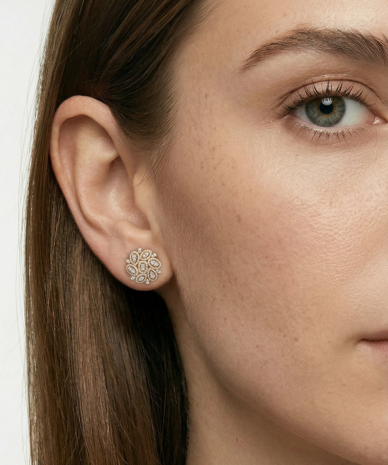Close-up of a woman wearing a silver earring with a white background