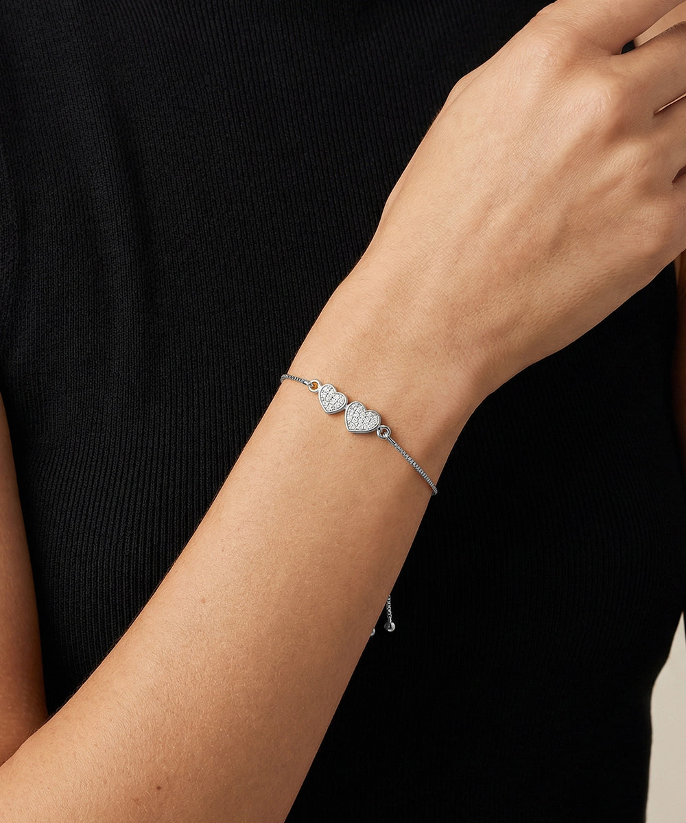 Silver bracelet on a person's wrist against a black background