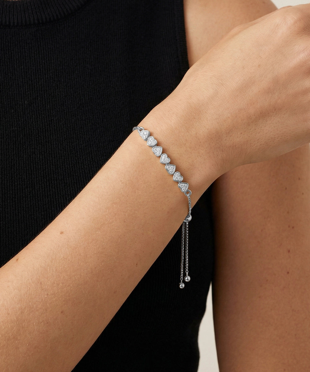 Silver bracelet on a person's wrist with a plain background