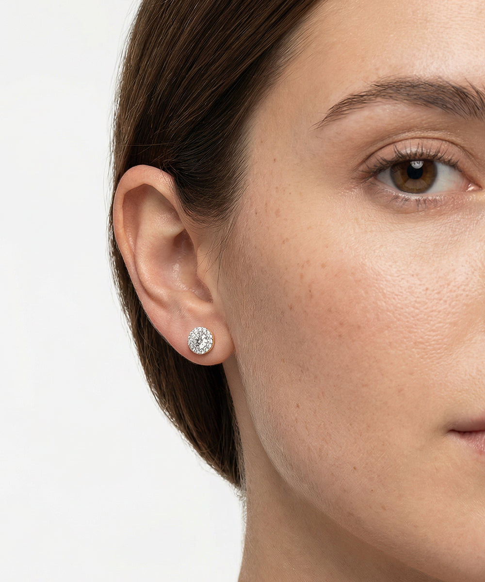 Close-up of a woman wearing a diamond earring on a white background