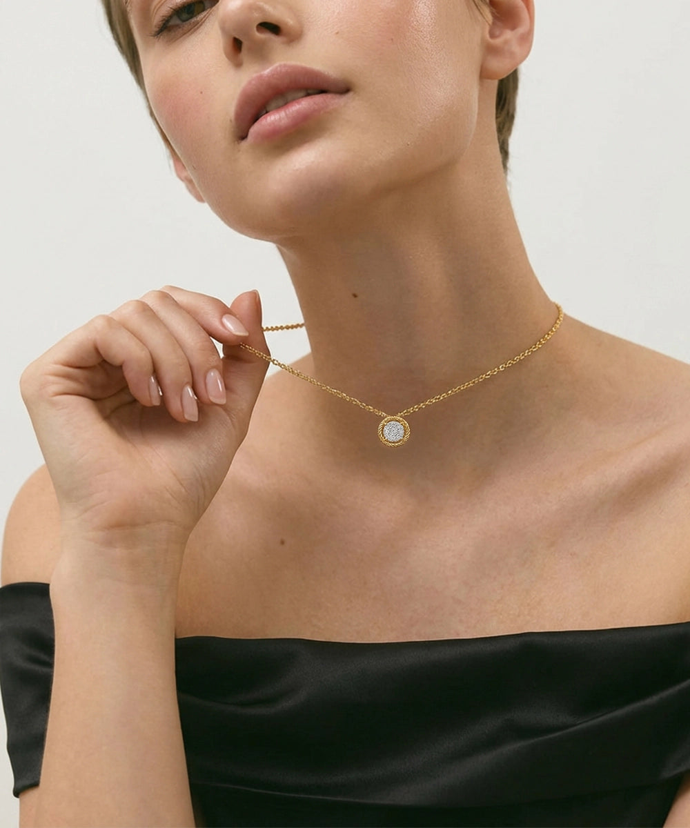 Woman wearing a silver necklace with a circular pendant on a plain background