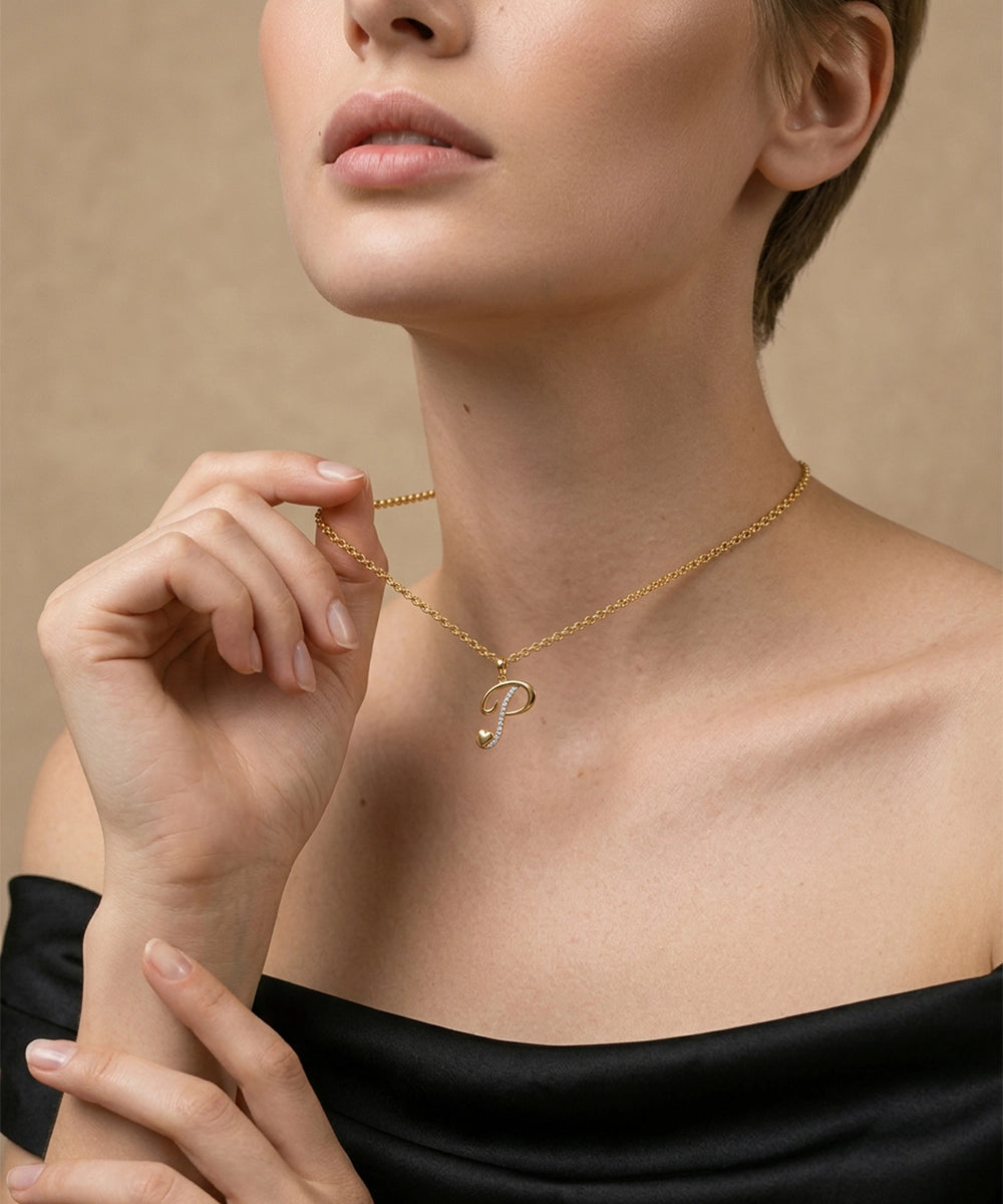 Woman wearing a gold necklace with a 'P' pendant against a beige background