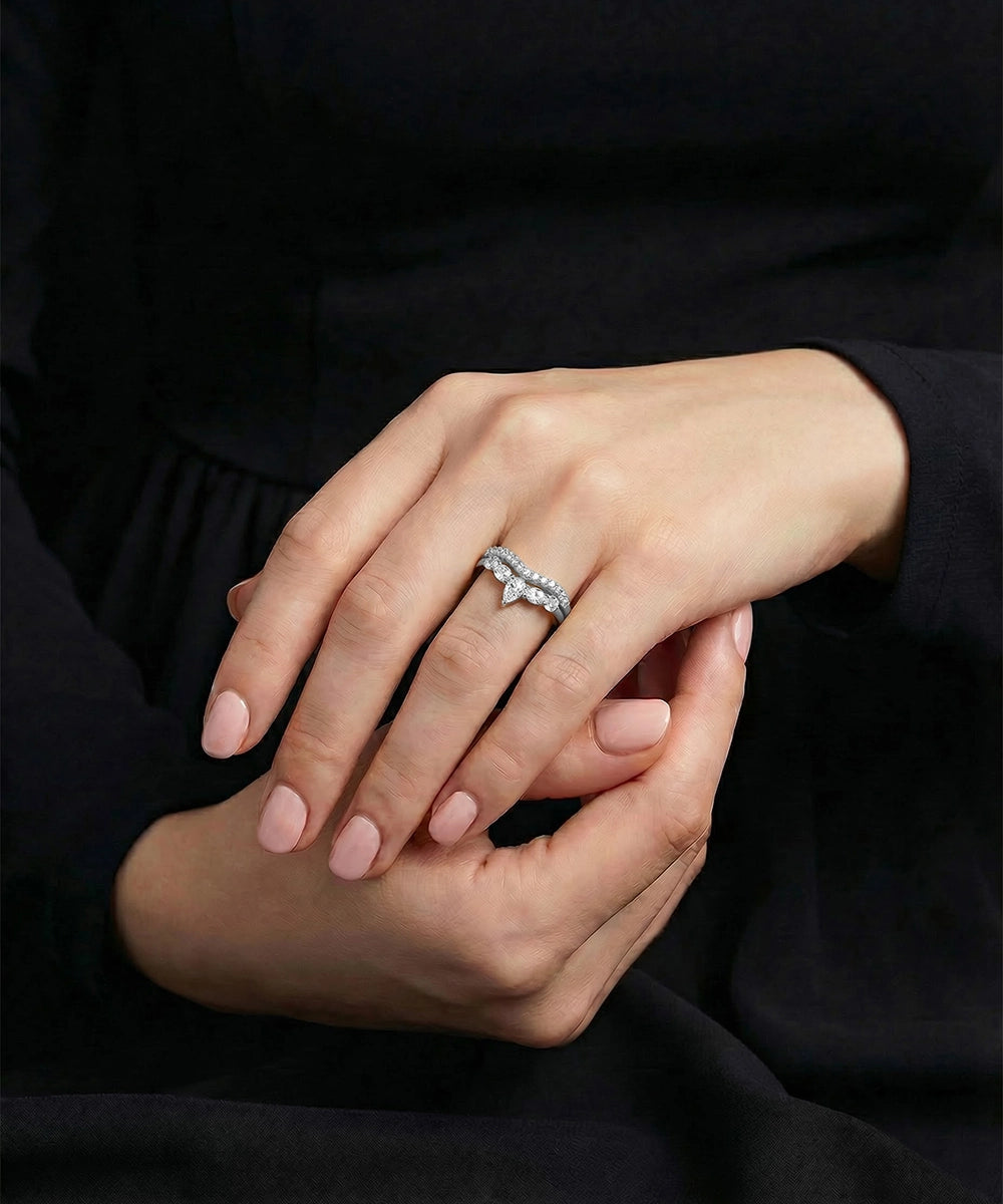 Close-up of hands with a ring on a dark background