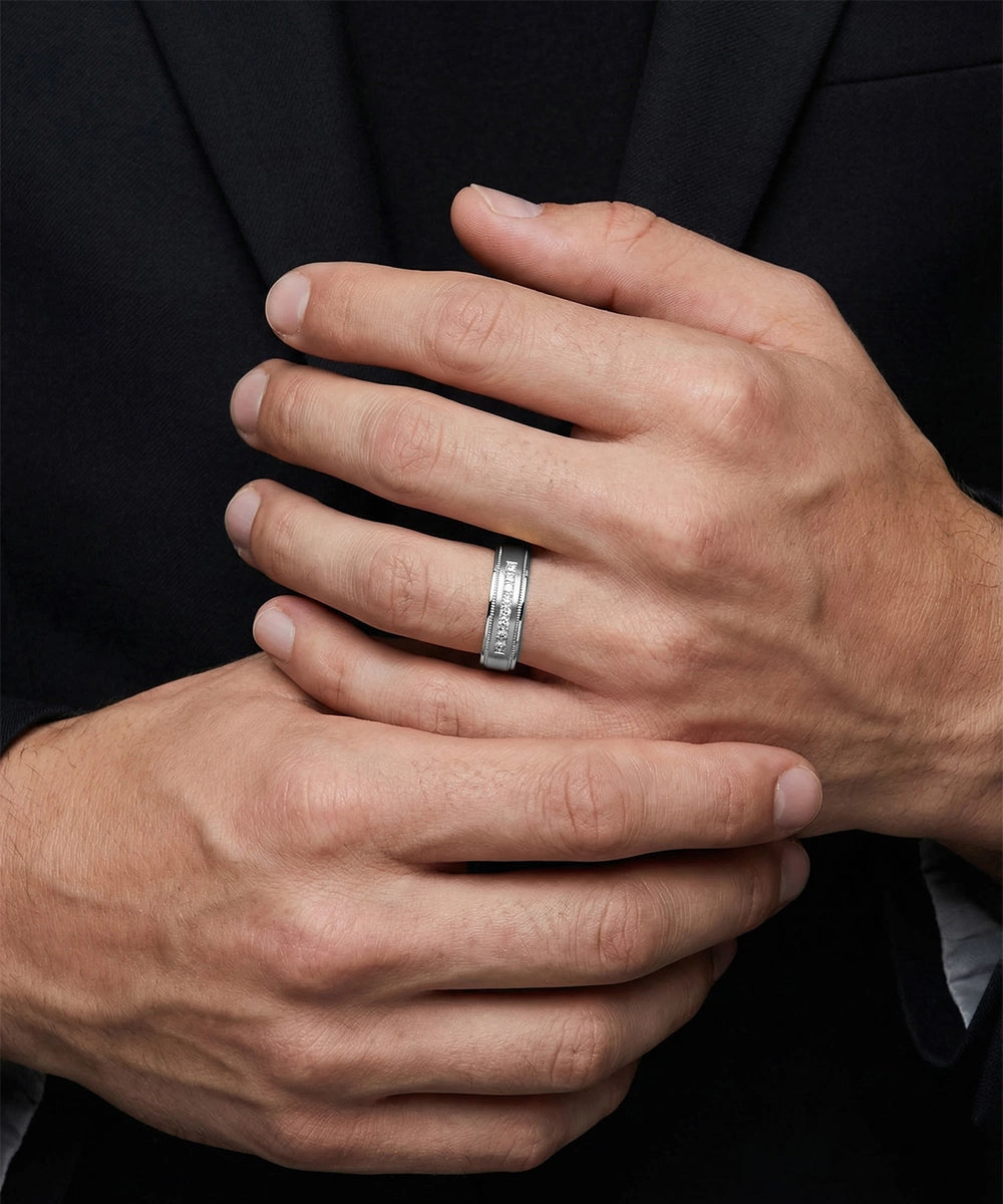 Close-up of a person's hands with a silver ring on a dark background