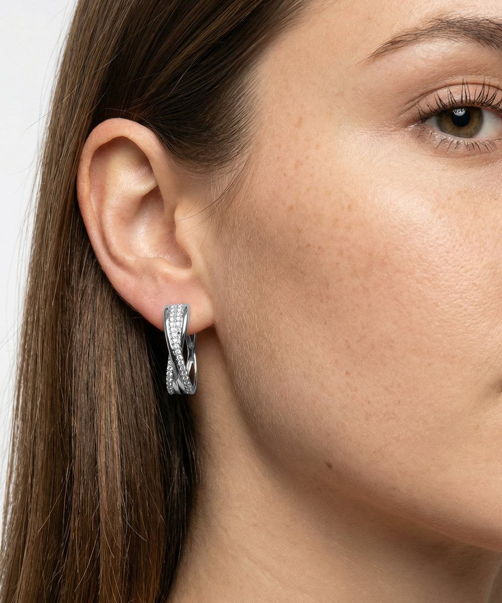 Close-up of a woman wearing a silver hoop earring with a blurred background