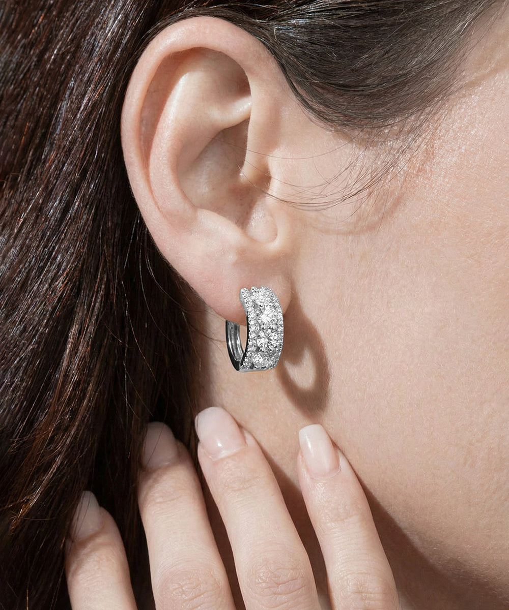 Close-up of a woman's ear wearing a silver hoop earring.