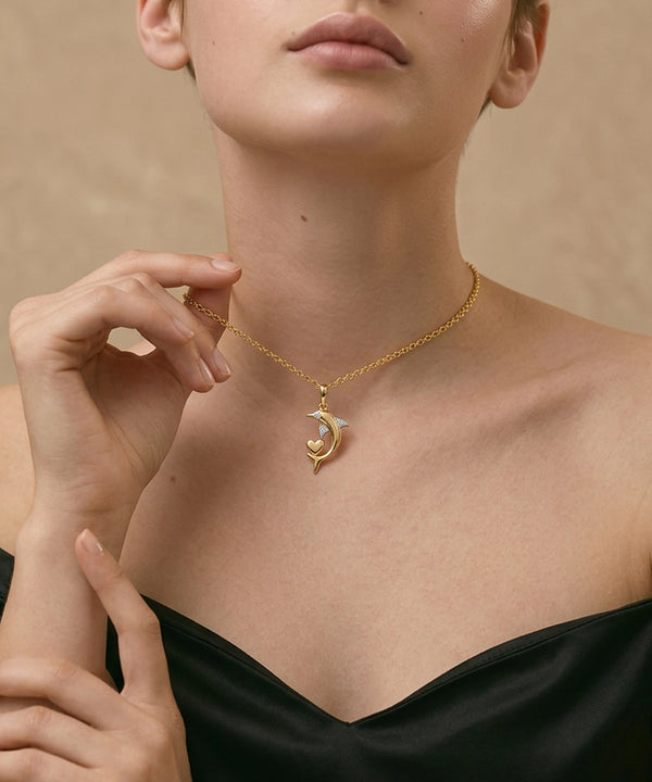 Woman wearing a gold necklace with a pendant against a beige background