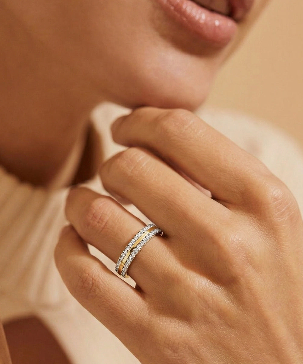 Close-up of a hand wearing a diamond ring with a soft focus background