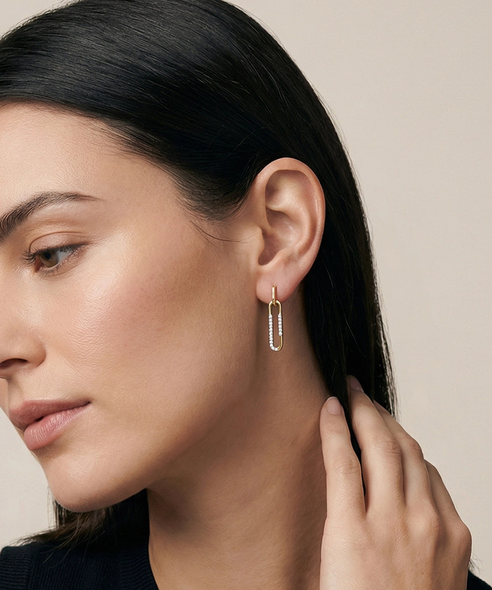 Close-up of a woman wearing a silver earring with a neutral background