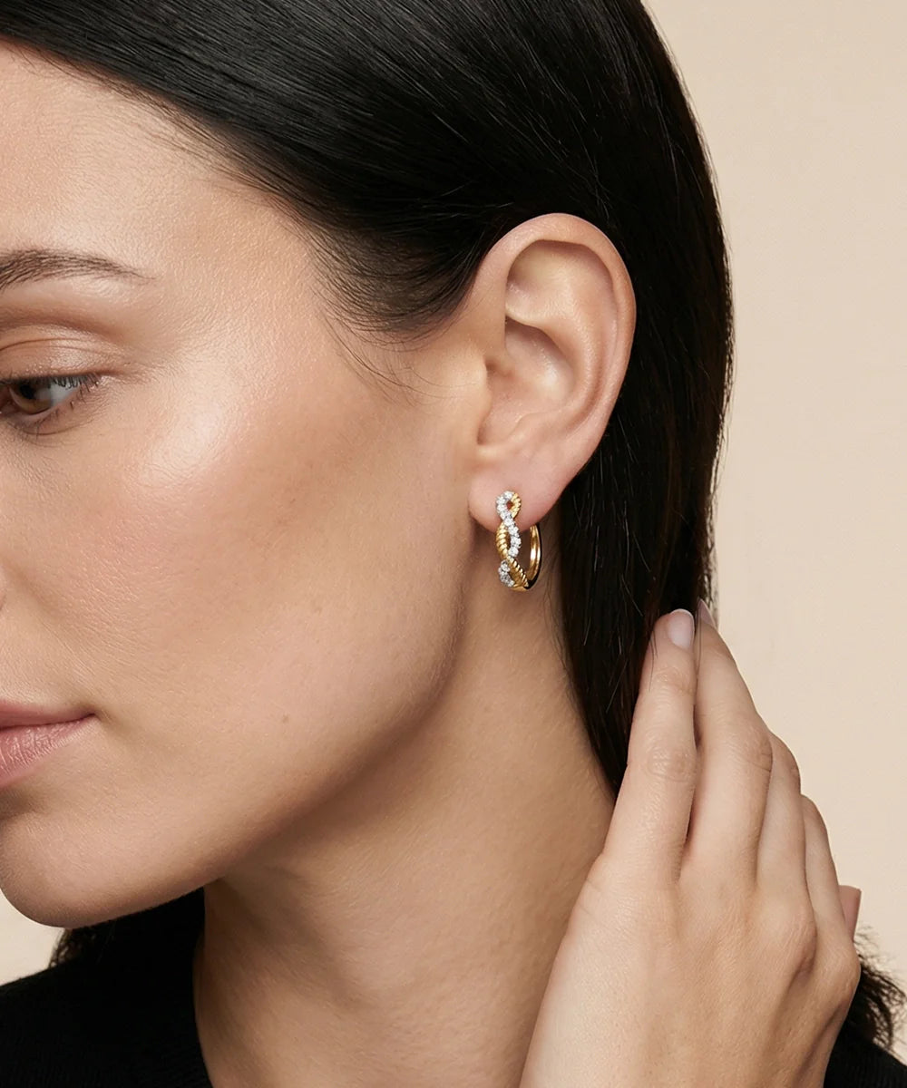 Close-up of a woman wearing a silver hoop earring on a beige background