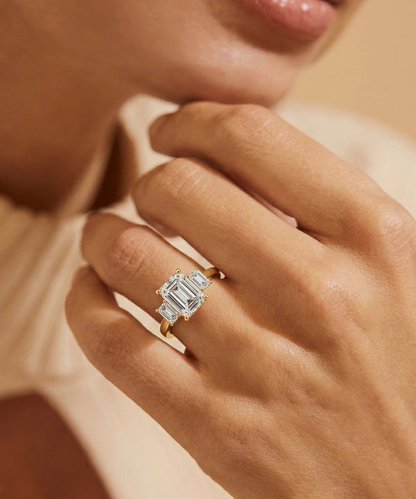 Close-up of a hand wearing a diamond ring with a soft focus background