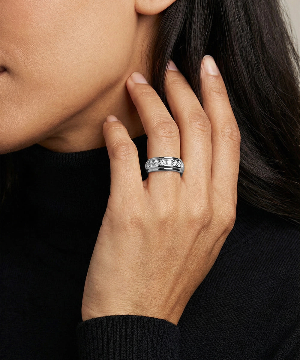 Close-up of a hand wearing a silver ring with a black background