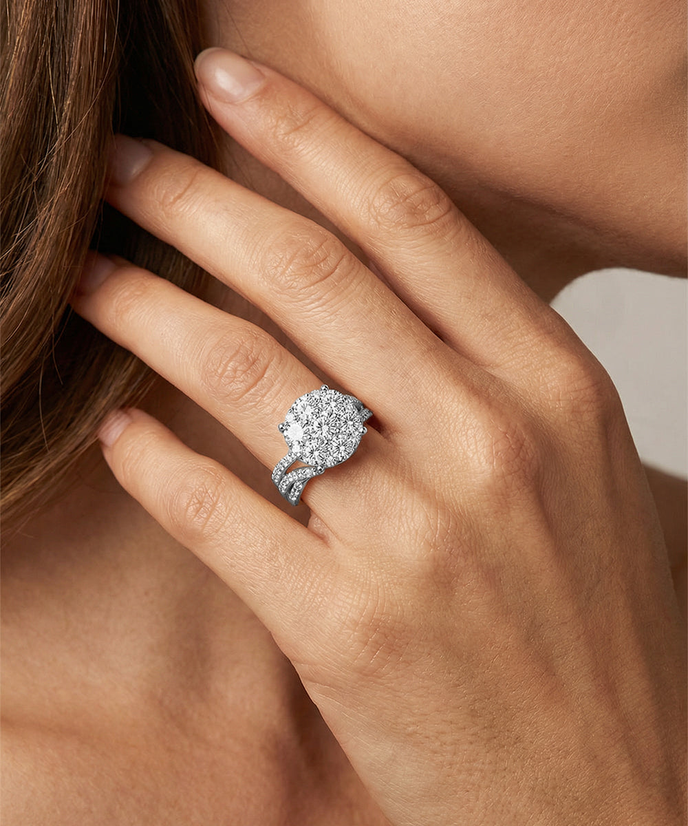 Close-up of a hand wearing a diamond ring on a neutral background